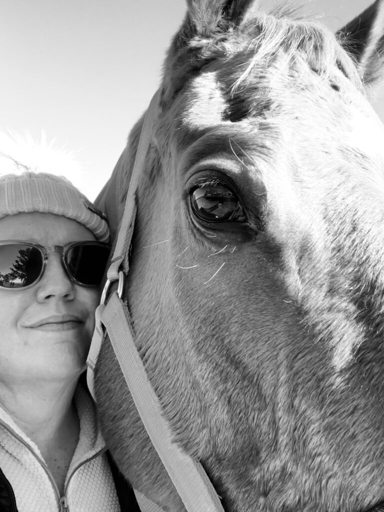 Close-up image of Kelly with one of her horses.